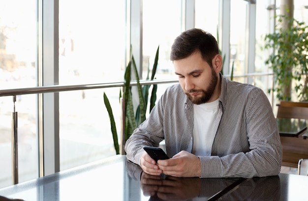 Rozmowa Telefoniczna. Portret Uśmiechnięty Inteligentny Broda Mężczyzna W Nowoczesnym Biurze Z Smartphone, Sms-y Na Aplikacji, Sprawdź E-mail, Przeglądanie Internetu. Atrakcyjny Biznesmen Freelancer W Kawiarni