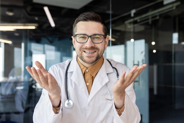 Rozmowa wideo konsultacja lekarska online młody odnoszący sukcesy lekarz patrzący w kamerę internetową i uśmiechający się