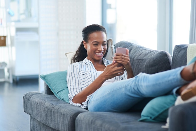 Rozmowa z kumplami Ujęcie młodej kobiety wysyłającej SMS-y przez telefon komórkowy w domu