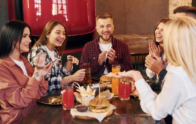 Rozmowa ze sobą Grupa młodych przyjaciół siedzących razem w barze przy piwie