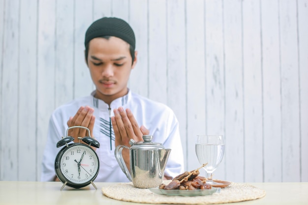 Rozmyte zdjęcie młodego muzułmanina modlącego się do Boga w czasie iftar