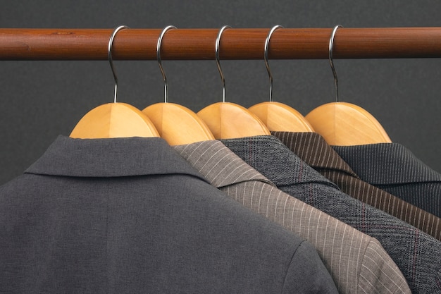 Różne damskie klasyczne kurtki biurowe wiszą na wieszaku do przechowywania ubrań
