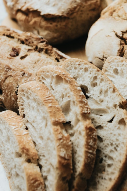 Różne domowe pieczywo na białym tle z czystego drewnaŚwieży smaczny chlebPiekarnia rustykalne chrupiące bochenki chleba i bułkiDomowe pieczywo naturalne Różne rodzaje świeżego chleba jako tło