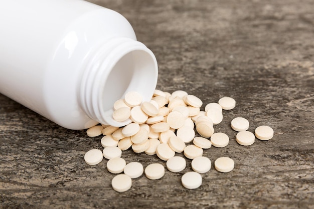 Różne leki i tabletki suplementów zdrowotnych wylane z butelki z lekarstwami opieki zdrowotnej i medycznego widoku z góry na kolorowym tle