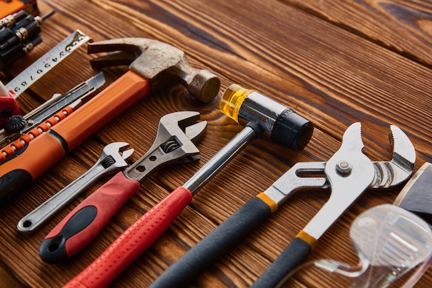 Różne narzędzia warsztatowe, drewniany stół. Profesjonalne narzędzie, sprzęt stolarski lub budowlany, śrubokręt i klucz, stosy i metalowe nożyczki