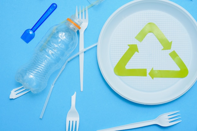 Zdjęcie różne plastikowe śmieci i znak recyklingu śmieci na kolorowym tle widok z góry