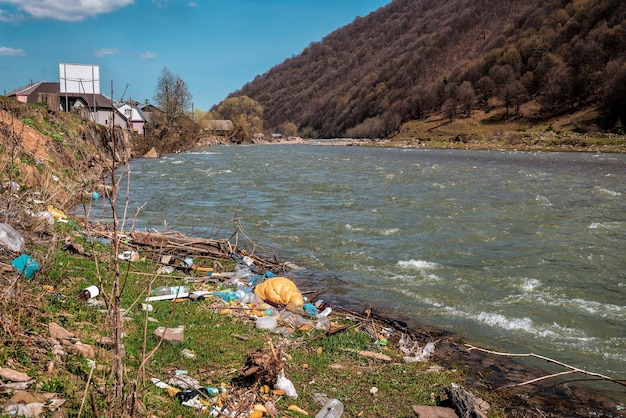 Różne plastikowe śmieci na brzegu rzeki