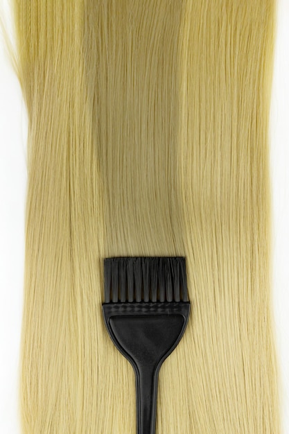 Zdjęcie różne profesjonalne narzędzia fryzjerskie czarny pędzel do farbowania włosów z pasmem blond włosów na białym tle koncepcja wyposażenia salonu fryzjerskiego zestaw fryzjerski premium narzędzia do farbowania włosów