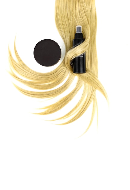 Zdjęcie różne profesjonalne narzędzia fryzjerskie lakier do włosów z balsamem do włosów i pasmem blond włosów na białym tle leżał płasko koncepcja spa pielęgnacji włosów