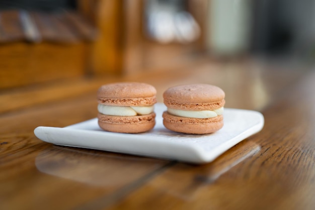 Różne pyszne ciasteczka macaron na stojaku na kwadratowy talerz