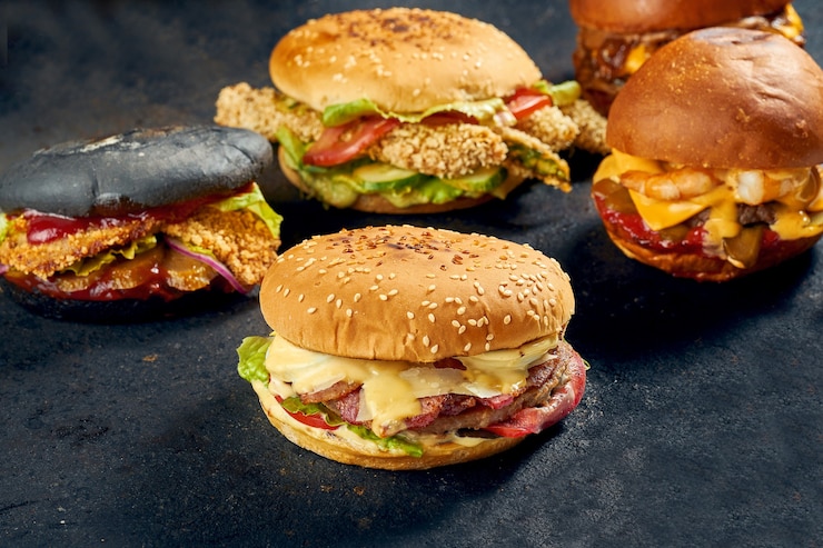 Zdjęcie różne rodzaje burgerów na ciemnym tle. zestaw burgerów