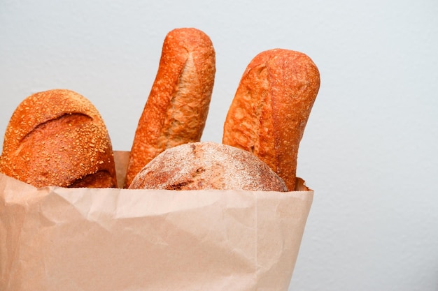 Różne rodzaje chleba w papierowej torbie na białym tle Natomiast z chlebem Baguette chleb jedzenie pieczenie i gotowanie koncepcja zbliżenia chleba w papierowych torbach