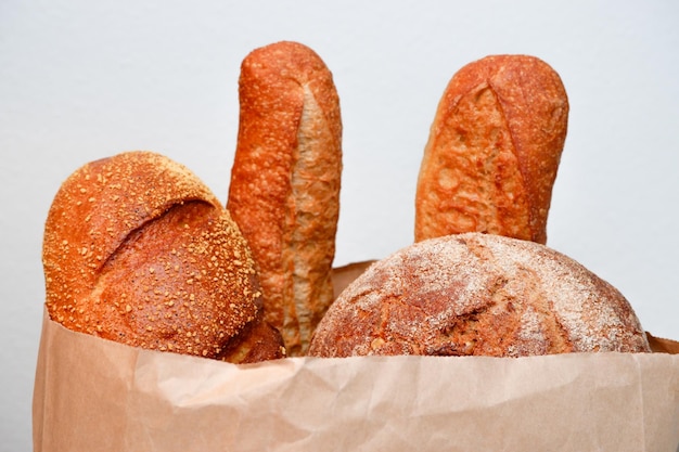 Różne rodzaje chleba w papierowej torbie na białym tle Natomiast z chlebem Baguette chleb jedzenie pieczenie i gotowanie koncepcja zbliżenia chleba w papierowych torbach