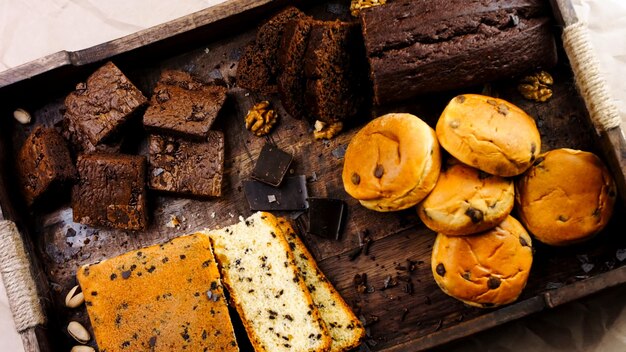 Różne rodzaje ciast ułożonych na drewnianej tacy