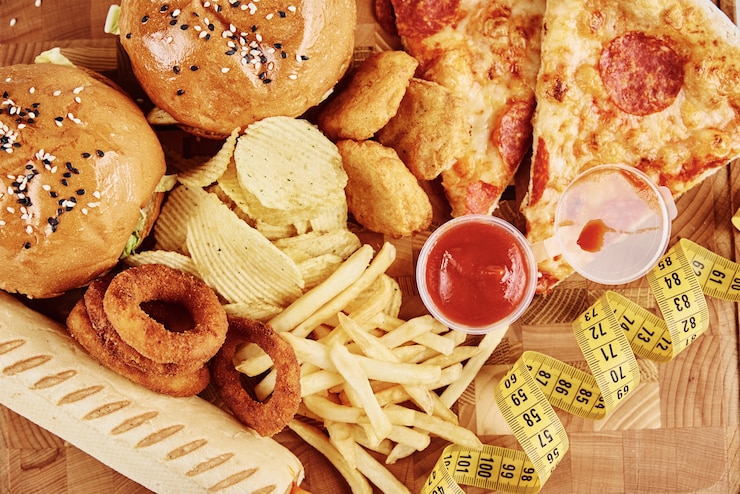 Zdjęcie różne rodzaje fastfoodów i przekąsek na stole z miarką