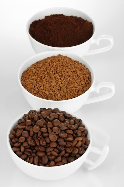 Różne rodzaje kawy w trzech filiżankach na białym tle