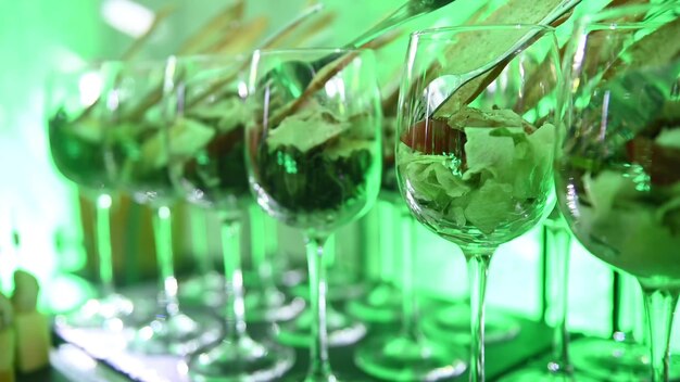 Różne rodzaje przekąsek i napojów na zabawną imprezę Stół w formie bufetu zielone światło neonowe