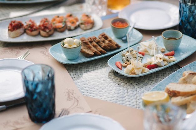 Różne rodzaje serów na serwowanym stole na letnim tarasie w koncepcji jedzenia w kawiarni różnego rodzaju
