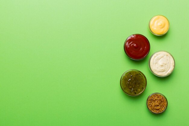 Różne rodzaje sosów w miskach na kolorowej tablicy Widok z góry różne sosy kopiowanie miejsca