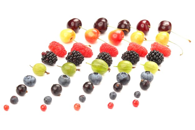 Różne soczyste jagody są ułożone w rzędach na białym tle. przydatne pokarmy witaminowe