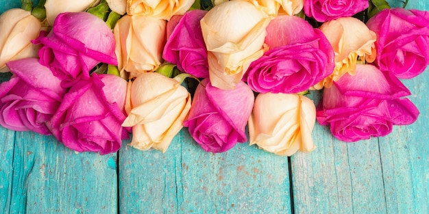 Różne świeże róże wielobarwne na turkusowym tle drewnianych. Świąteczna koncepcja na Wesela, Urodziny, 8 marca, Dzień Matki lub Walentynki. Kartka z życzeniami, układ płaski, baner