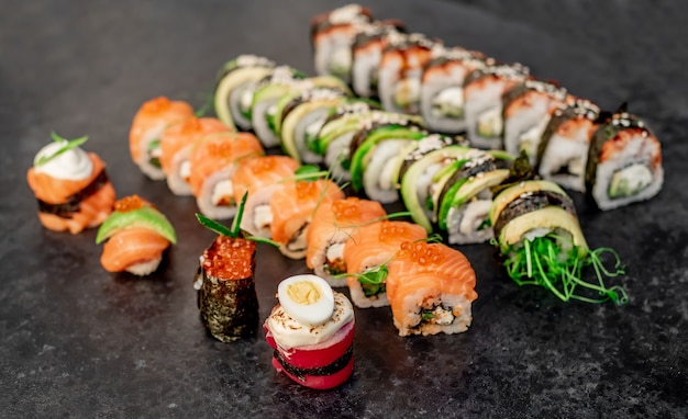 Różne zestawy sushi nigiri i rolki sushi na kamiennym tle