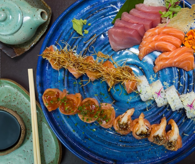 Różni się japońskie sushi na eleganckim niebieskim talerzu