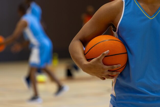 Różni zawodnicy koszykówki noszący niebieskie ubrania sportowe i grający w koszykówkę na siłowni