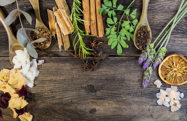 Różnorodność kwiatów zioła świece i esencje do aromaterapii na drewnianym drewnie