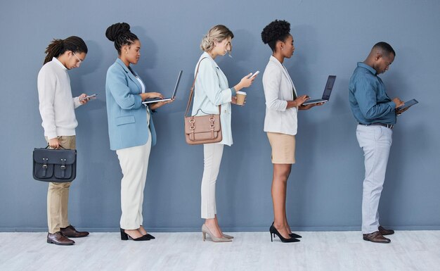 Różnorodność ludzi biznesu lub rozmowa kwalifikacyjna czekająca na linię rekrutacyjną w kolejce technologicznej lub w rzędzie HR Wolni mężczyźni lub kobiety w dziale zasobów ludzkich zatrudniający lub wprowadzający biuro na telefonie laptopie lub tablecie
