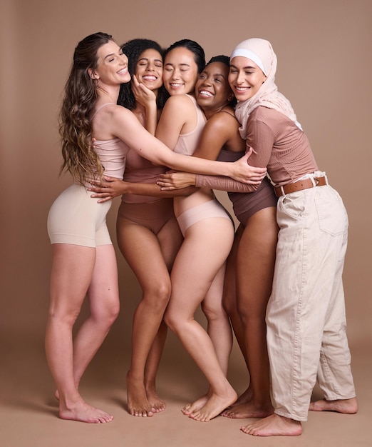 Różnorodność obejmuje piękne i pozytywnie nastawione do ciała kobiety w studio na brązowym tle Bielizna do pielęgnacji skóry i grupa różnych młodych lub szczęśliwych modelek w makijażu z zamkniętymi oczami pozujących do miłości własnej