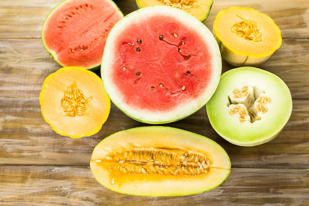 Różnorodność organicznych melonów pokrojonych na stół z drewna.