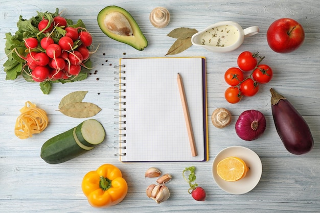 Różnorodność produktów spożywczych i notatnik na stole w kuchni