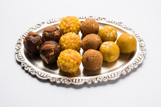 Różnorodność słodkiego laddu lub laddoo na srebrnym talerzu, słodki knedel złożony z bundi, suszonych owoców lub rava, selektywne skupienie