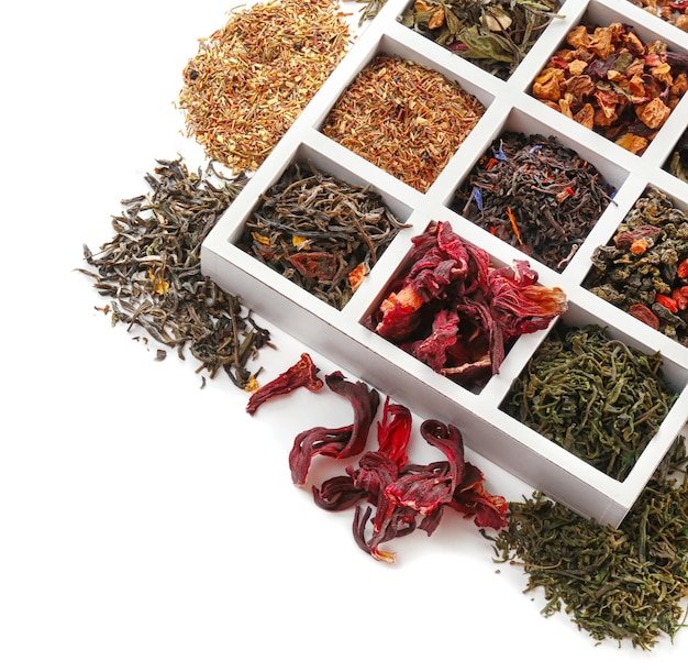 Różnorodność suchej herbaty w drewnianym pudełku odizolowywającym na bielu