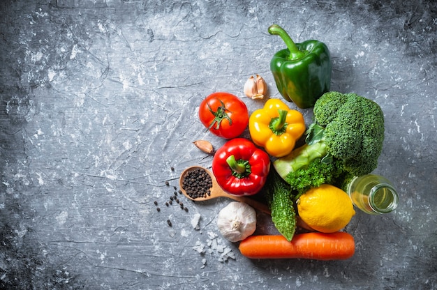 Różnorodnych świeżych warzyw organicznie jedzenie dla zdrowego na nieociosanym tle