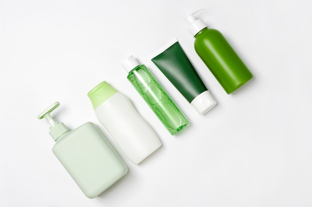 Różnych rozmiarów i kształtów pojemniki na tonik do demakijażu, mydło i szampon na białym tle. Naturalne organiczne produkty kosmetyczne