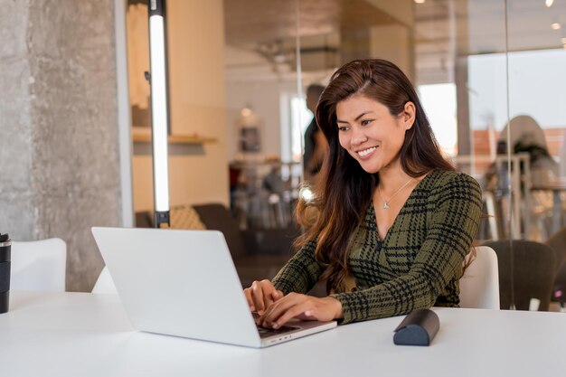 Zdjęcie rozochocona biznesowa dama pracuje na netbooku w biurze