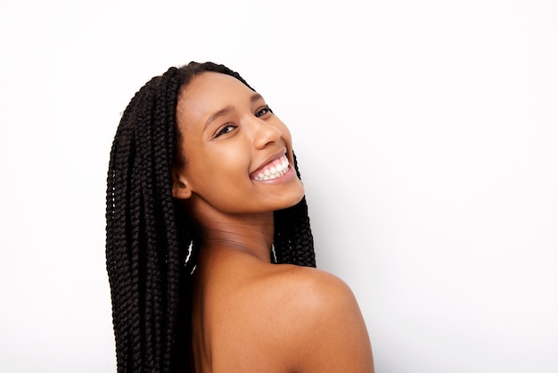 Rozochocona młoda afrykańska kobieta ono uśmiecha się na białym tle z galonowym włosy