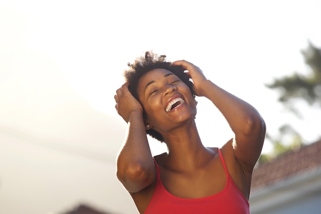 Rozochocona młoda afrykańska kobieta śmia się outdoors