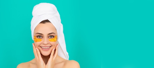 Rozochocona młoda dama ma kolagenowe złote przepaski na oko na twarzy z ręcznikiem Pięknej kobiety odosobniona twarz