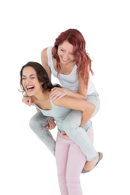 Rozochocona młoda kobieta piggybacking szczęśliwego przyjaciela