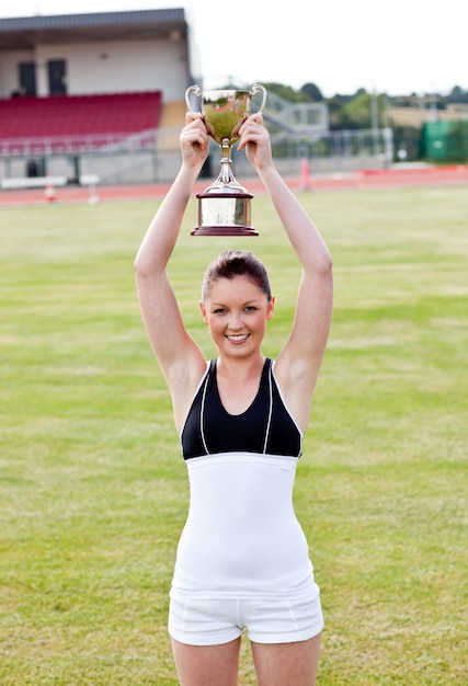 Zdjęcie rozochocona żeńska atleta trzyma trophee