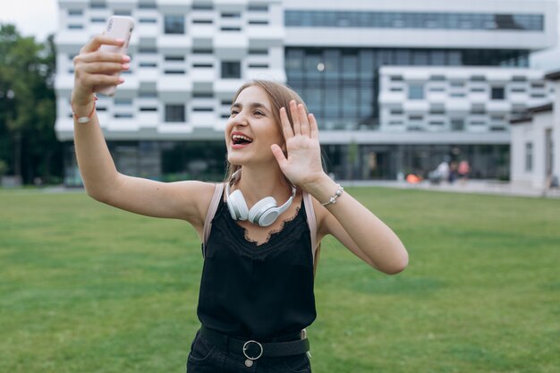 Rozochocony młoda dziewczyna nastolatek bierze selfie z hełmofonami.