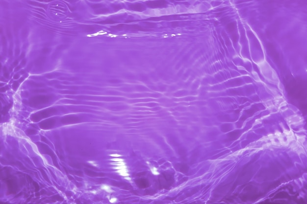 Rozogniskowanie niewyraźne przezroczyste fioletowe jasne, spokojne tekstury powierzchni wody z bańką powitalną