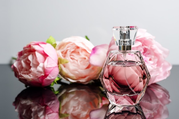 Różowa Butelka Perfum Z Kwiatami Na Czarno-białej Powierzchni
