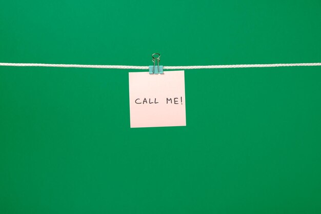 Różowa notatka na sznurku z tekstem "Zadzwoń do mnie"