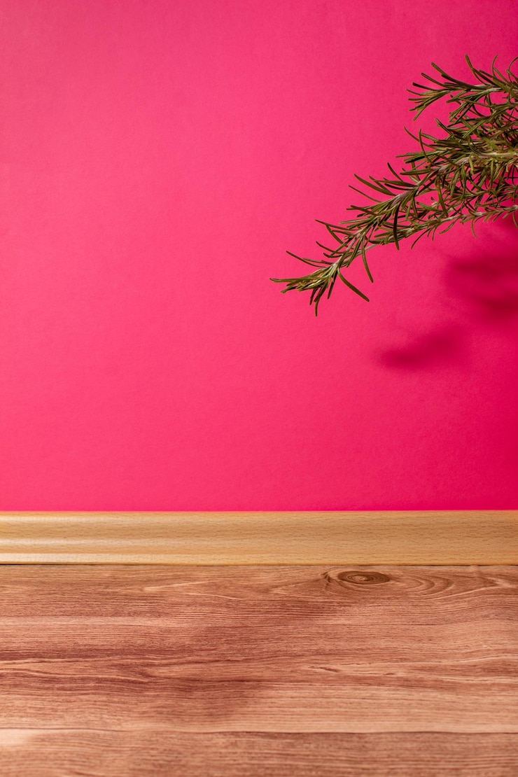 Zdjęcie różowa ściana w pokoju z drewnianą podłogą i zielonymi kwiatami