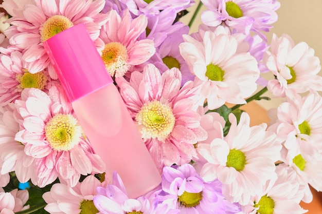 Różowa szklana butelka z kwiatami purfume i chryzantemy