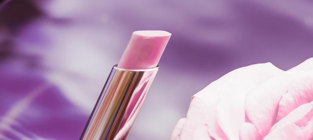 Różowa szminka i kwiat róży na płynnym tle wodoodporny makijaż glamour i produkt kosmetyczny z błyszczykiem dla luksusowego projektu wakacyjnego marki kosmetycznej